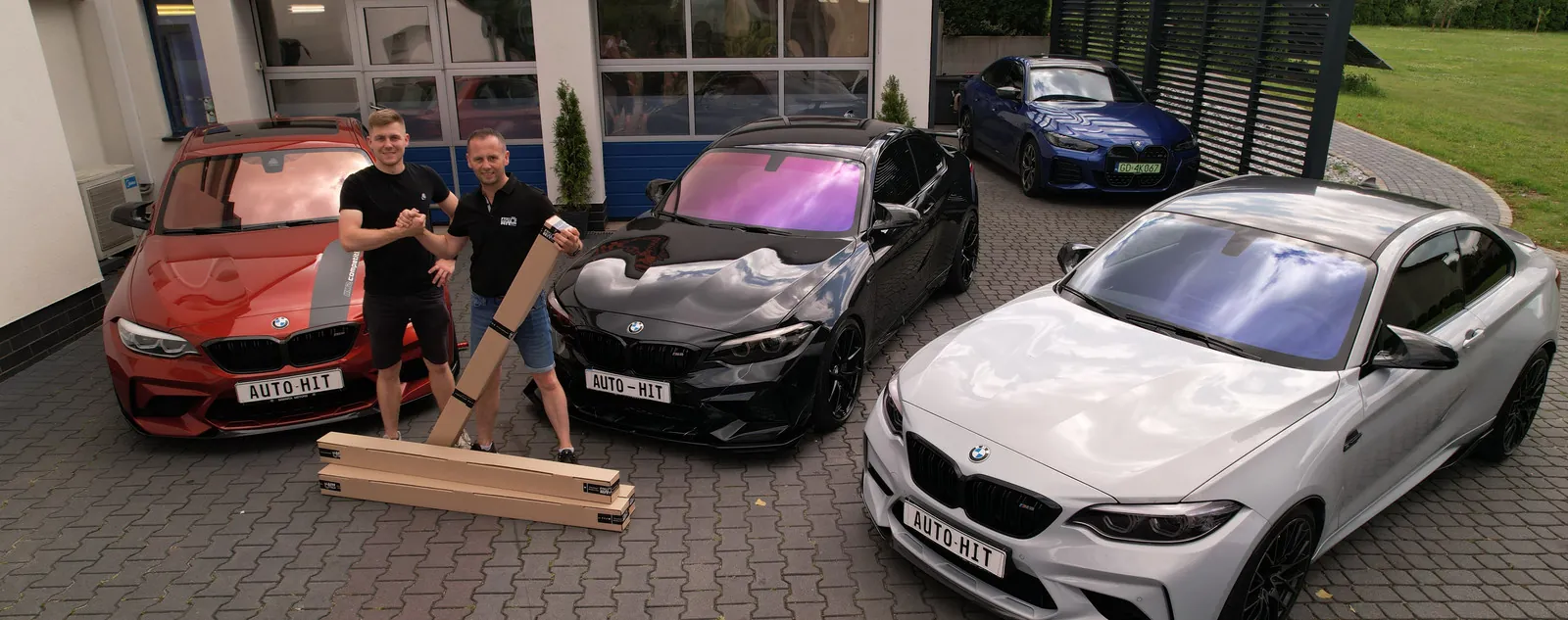 Jacek i Hubert Szymczak z rolkami folii przed warsztatem Auto-Hit