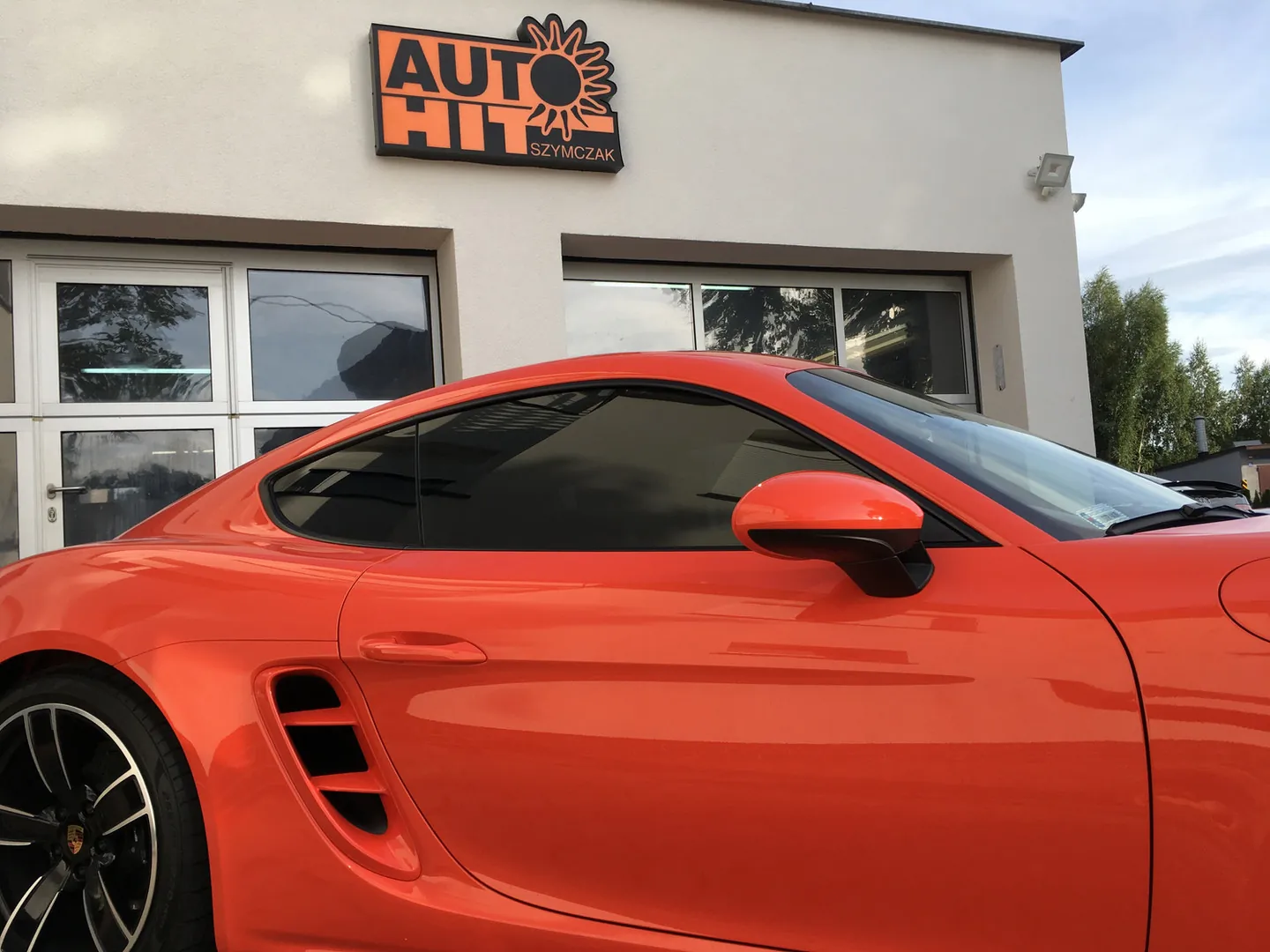 Porsche z przyciemnionymi szybami przed warsztatem Auto-Hit